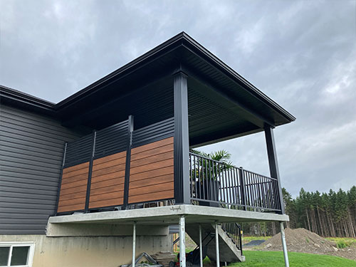 Un balcon avec une balustrade sur un deck en bois, offrant une vue dégagée sur l'environnement environnant.