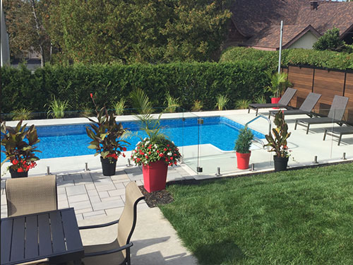 Un arrière-cour avec une piscine et des meubles de jardin.