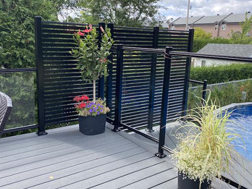 Un deck avec une piscine et une barrière de sécurité.