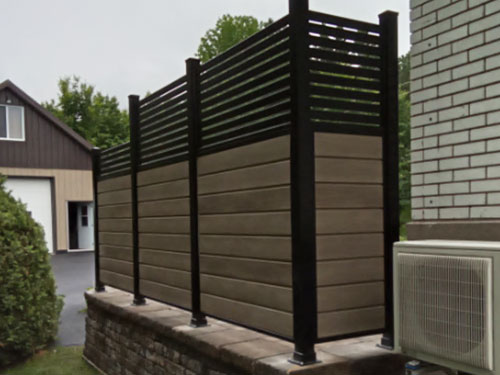 Une clôture en lattes de bois sur un terrasse.