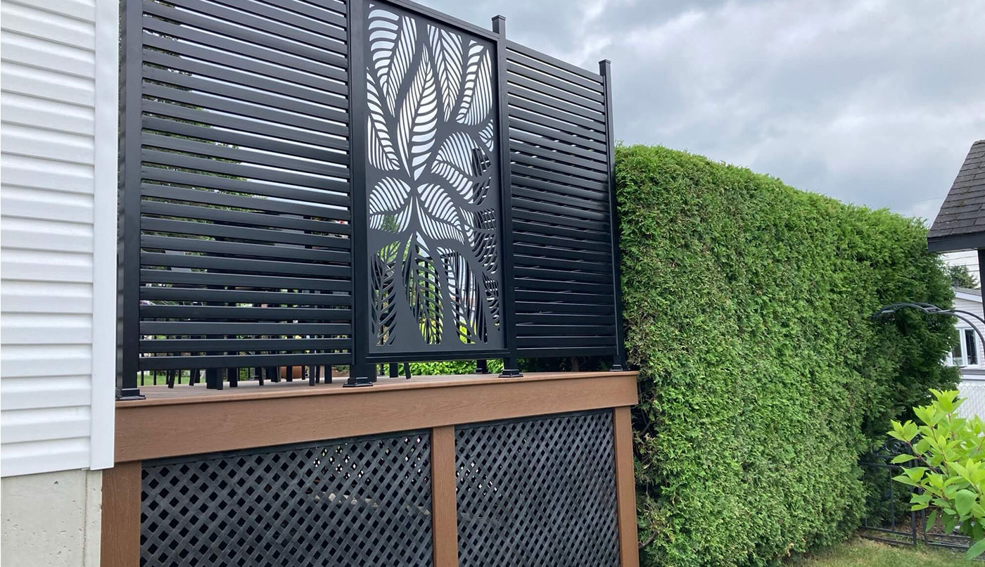 Une clôture avec mur d'intimité en aluminium noir créé un contraste visuel élégant et moderne.