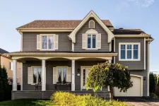 Maison traditionnelle avec un deuxième étage ajouté au-dessus du garage.